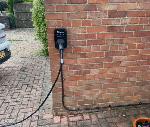 Ohme Home Pro EV charger installed on exterior wall of a home in Norwich